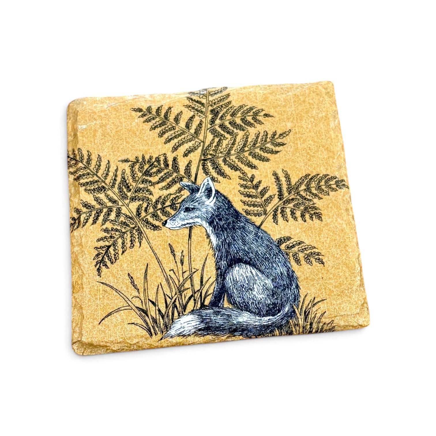 A square decorative stone or tile coaster featuring a detailed illustration of a gray fox sitting among dark green ferns on a textured golden-yellow background, shown on a plain white background.