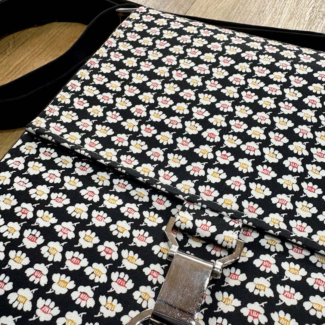 Floral-patterned bag with a metal buckle on a wooden surface_Amanda Scott_Just Makers