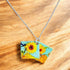 Necklace with a pendant featuring sunflower designs on a light gray background_Nancy Jones_Just Makers