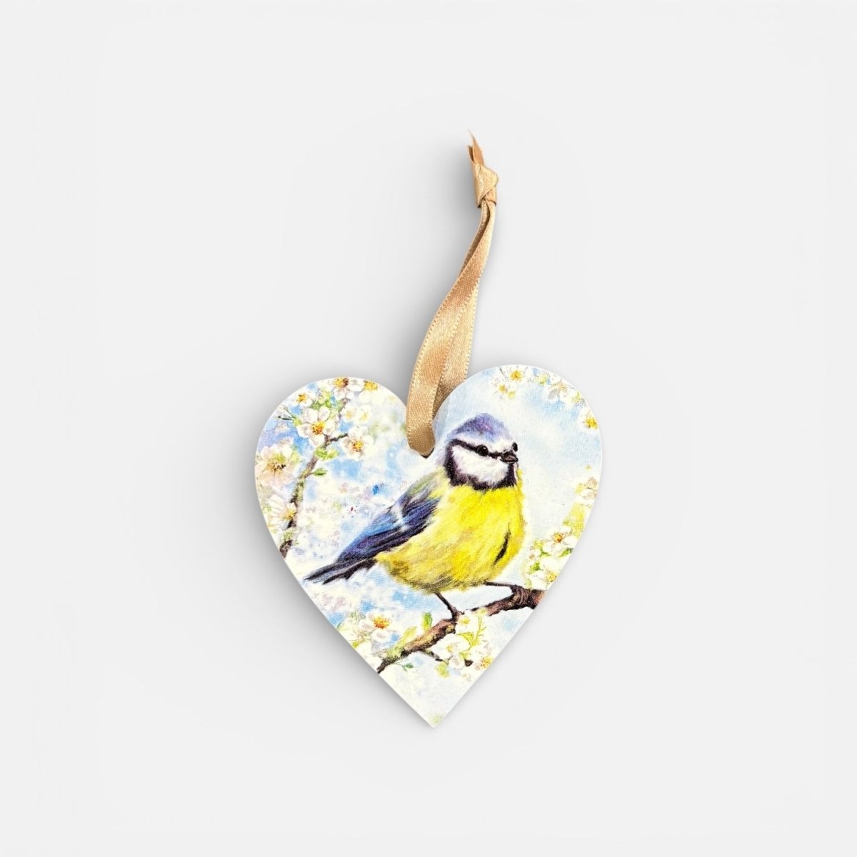 Heart-shaped wooden ornament with a painted bird and flowers on a white background
