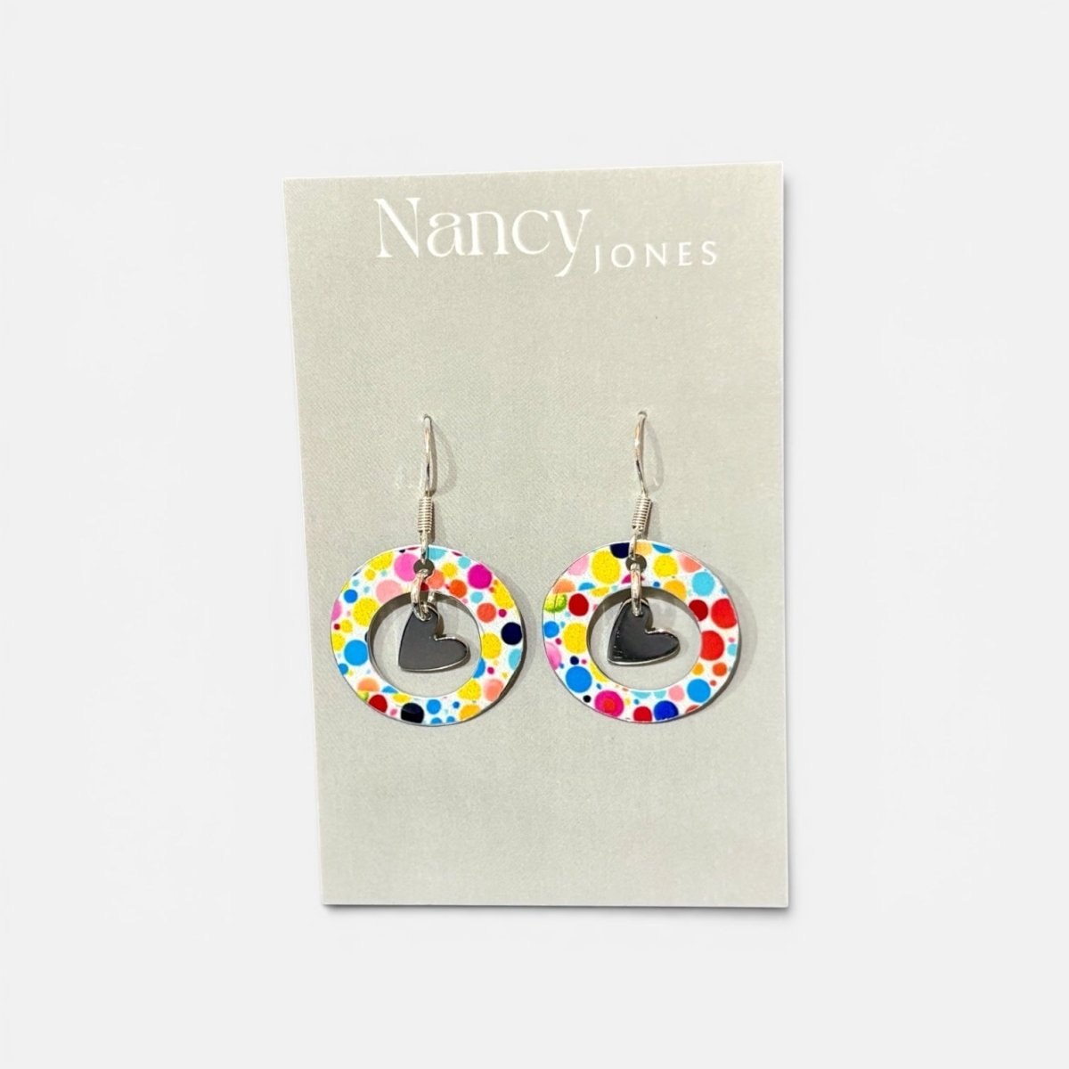 Colorful circular earrings with heart details on a Nancy Jones card.