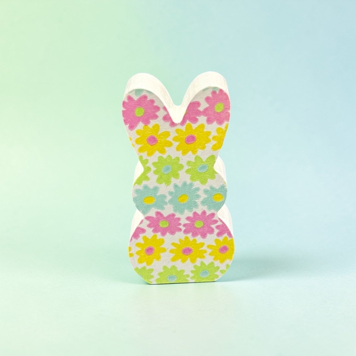 Floral-patterned wooden bunny figure on a light blue background