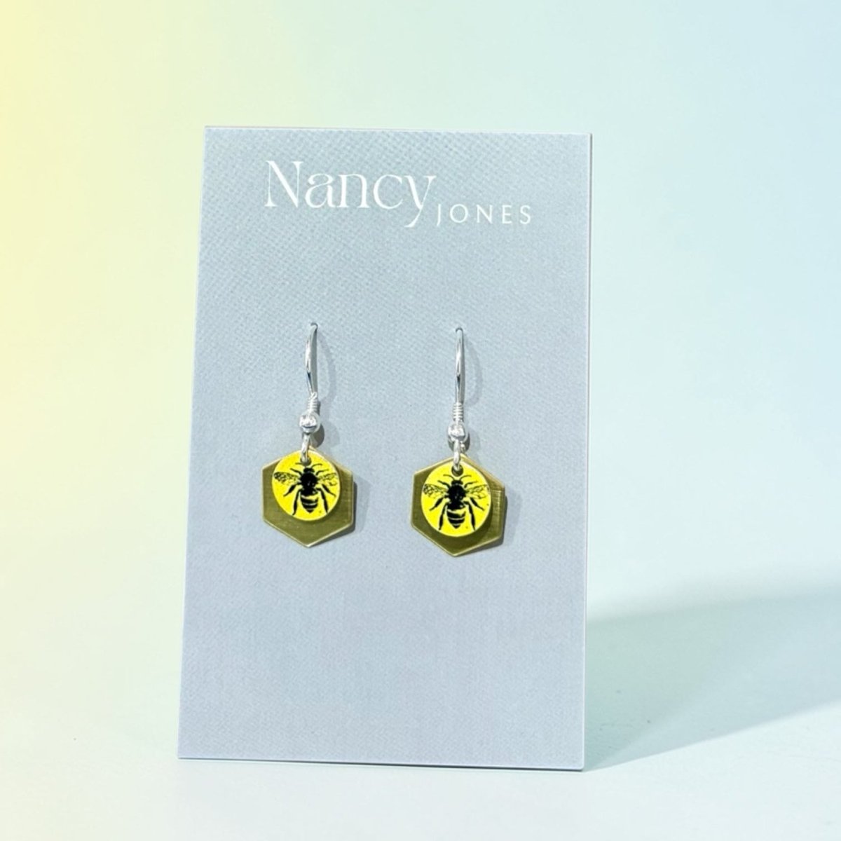 Hexagonal earrings with bee design on a Nancy Jones card