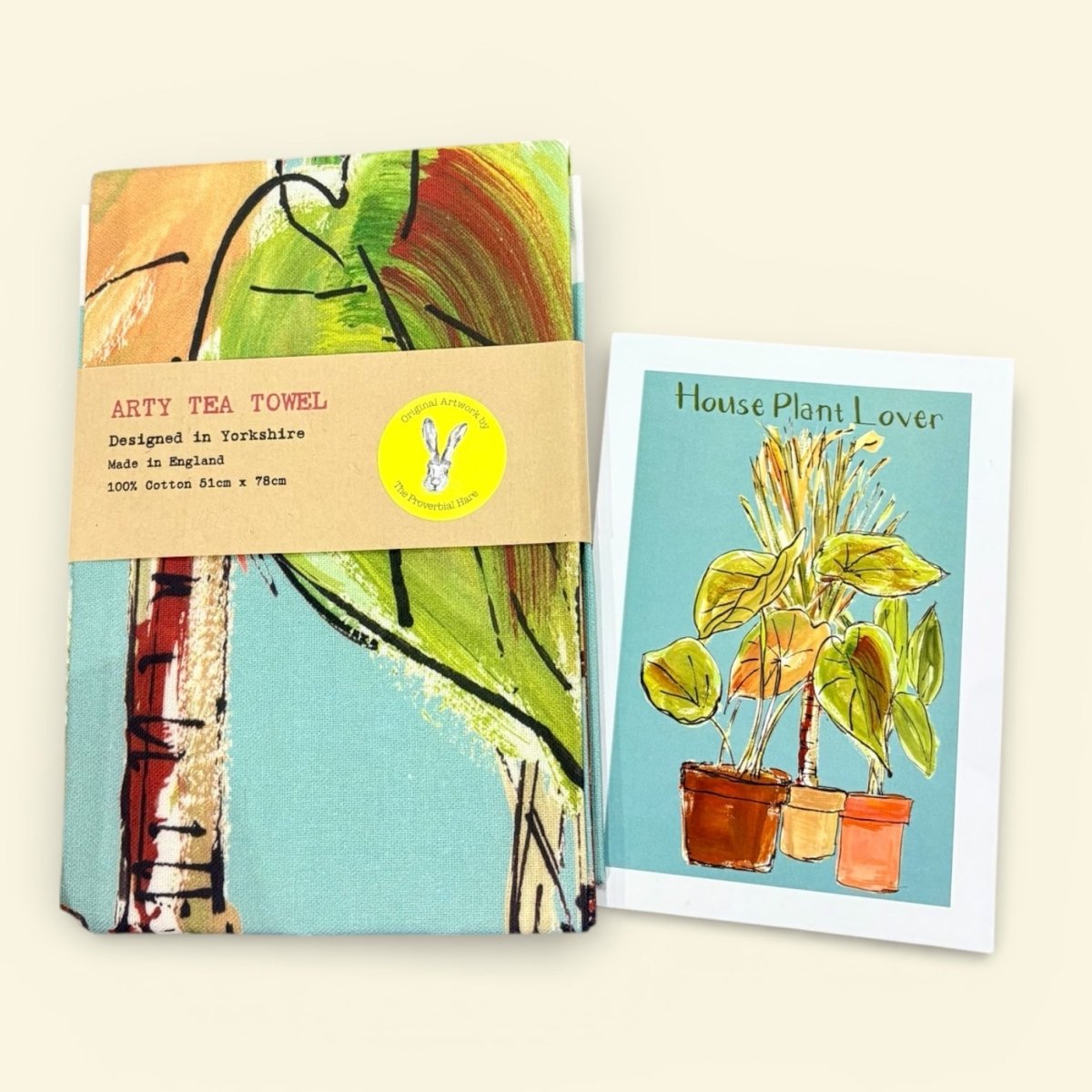 Tea towel with artistic design and card featuring house plants on a light beige background