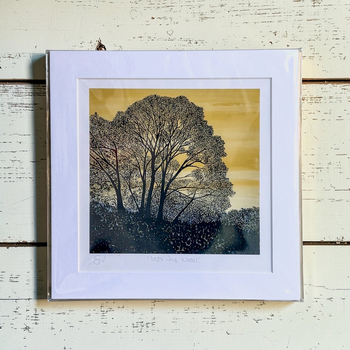 Framed artwork of a tree on a textured wooden surface