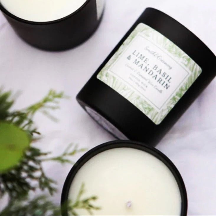 Two candles with labels on a white surface, one of which is open to reveal a green interior.