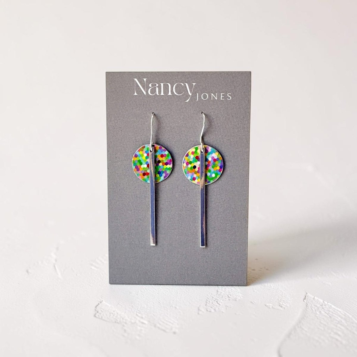 Colorful dot earrings on a Nancy Jones card against a white background