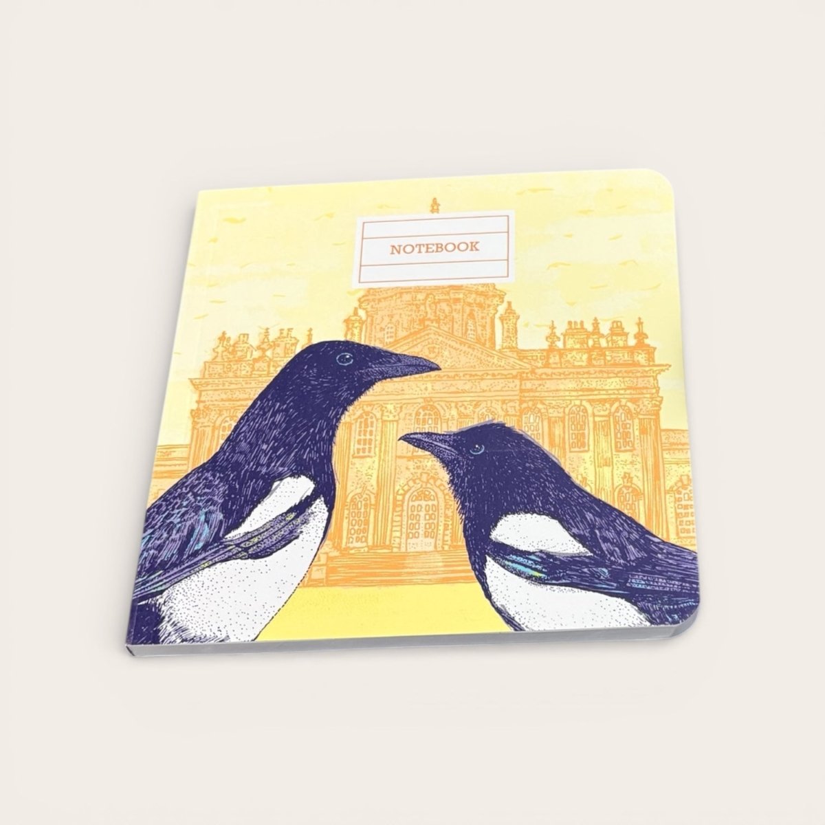 Notebook with illustrations of two magpies on a yellow background