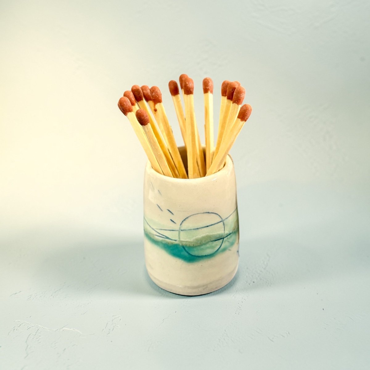 Ceramic match holder with matches on a light background