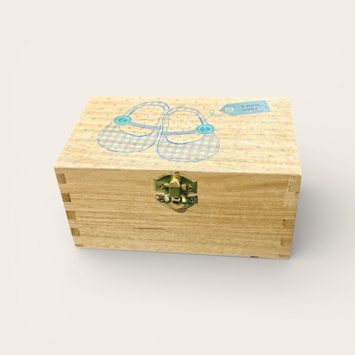 Wooden box with baby shoes design on a light background