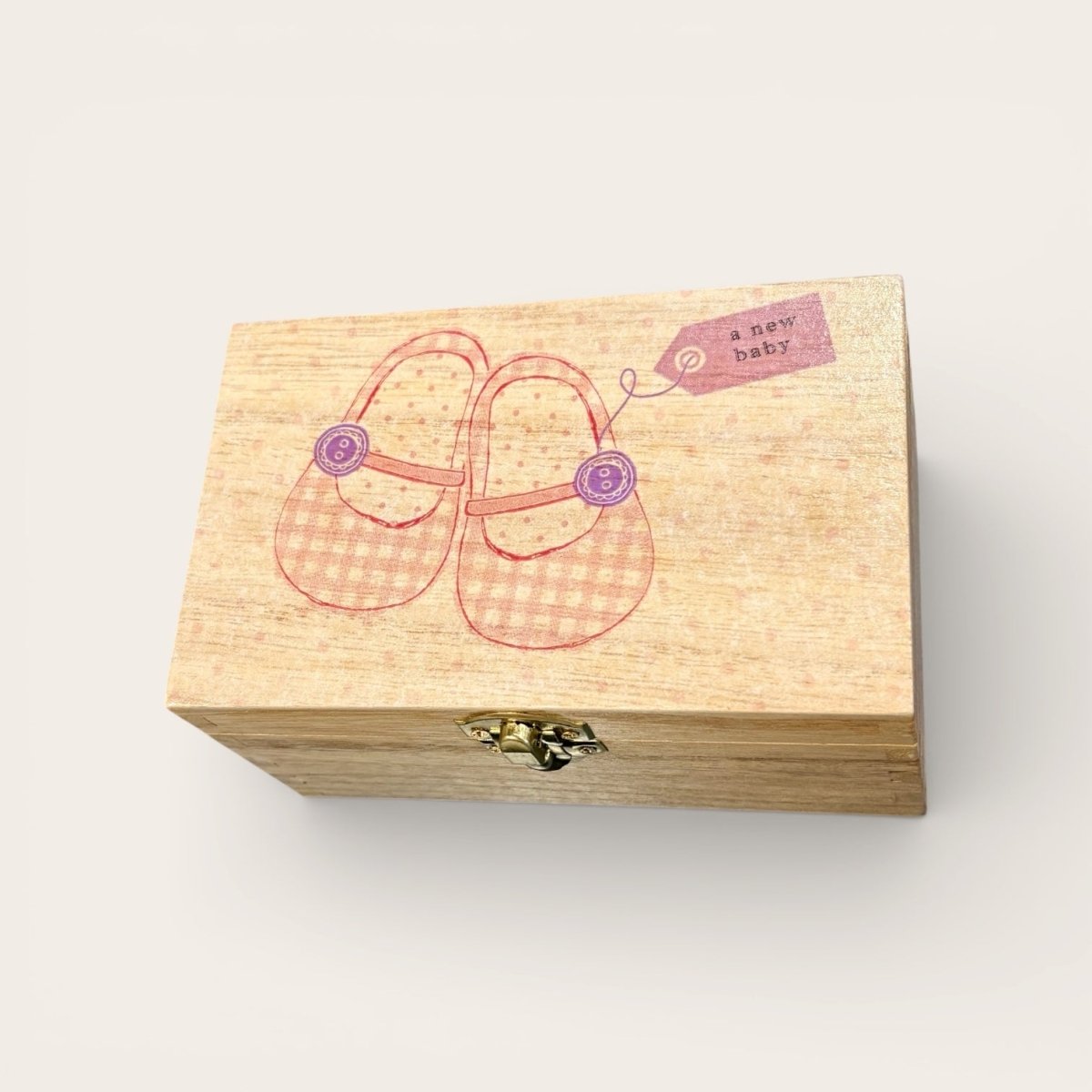Wooden box with baby shoes illustration and &