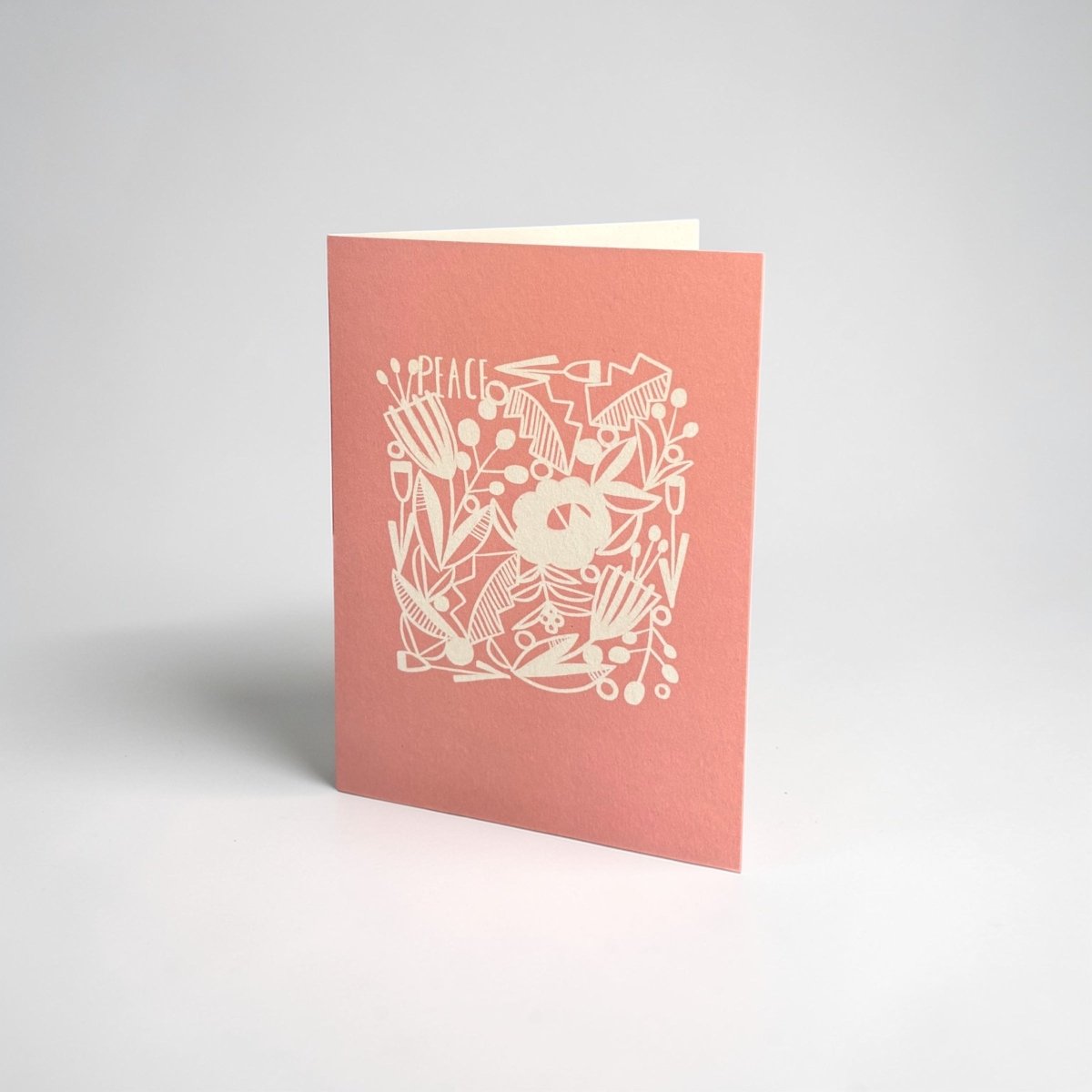 Pink greeting card with white floral design and &