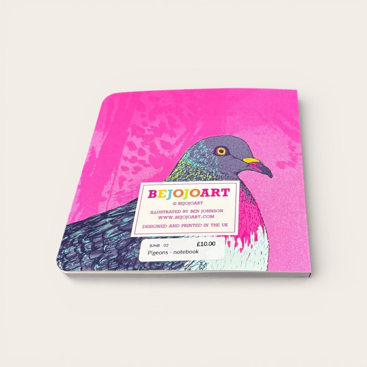 Notebook with a pigeon illustration on a pink background, featuring the brand &