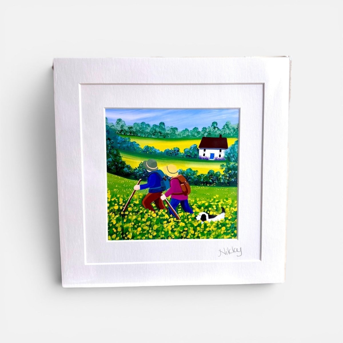 Framed artwork of two people walking a dog in a field with a house in the background.