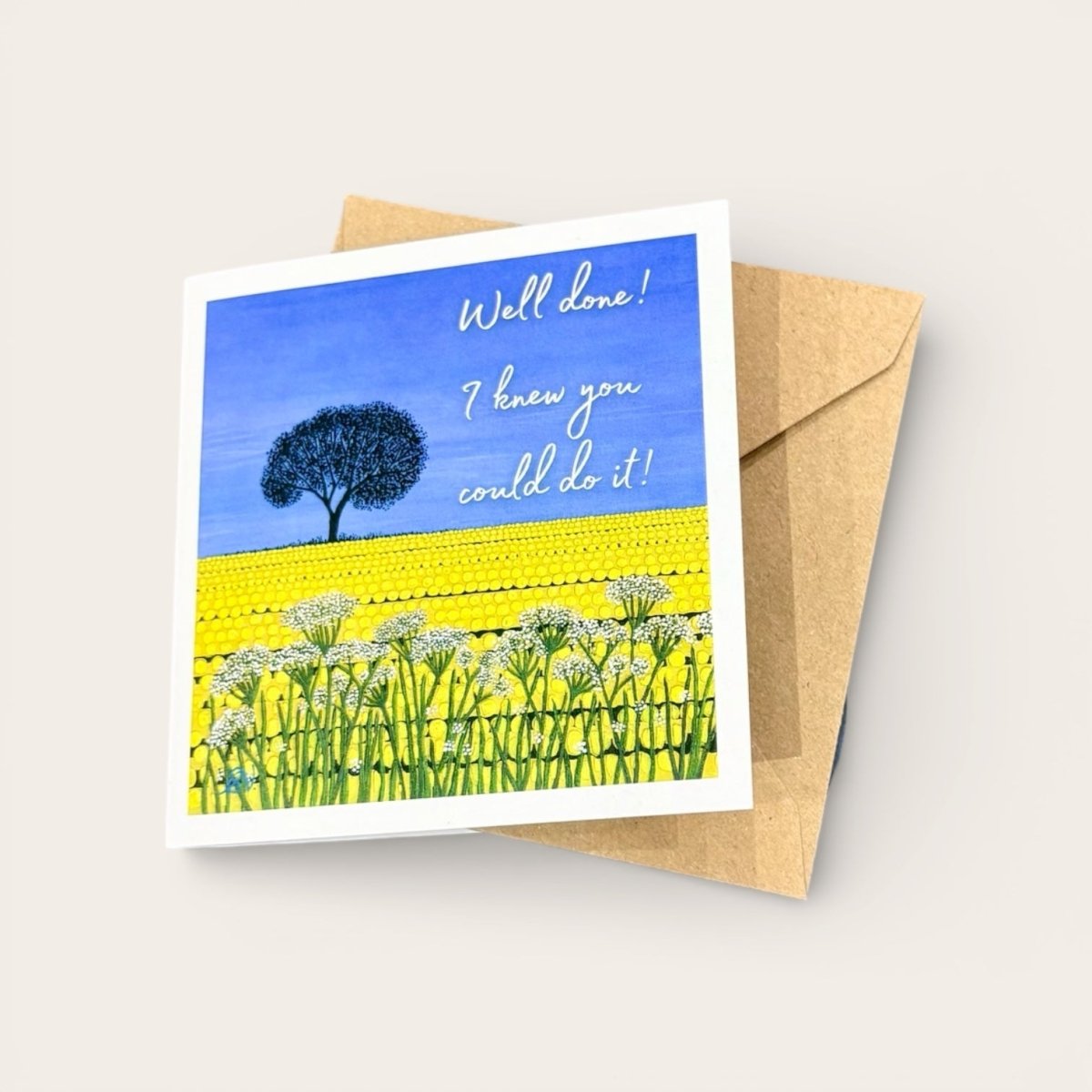 Greeting card with a blue sky, yellow field, and white flowers, featuring the text &