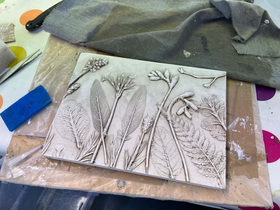 A botanical bas relief tile in the process of being made