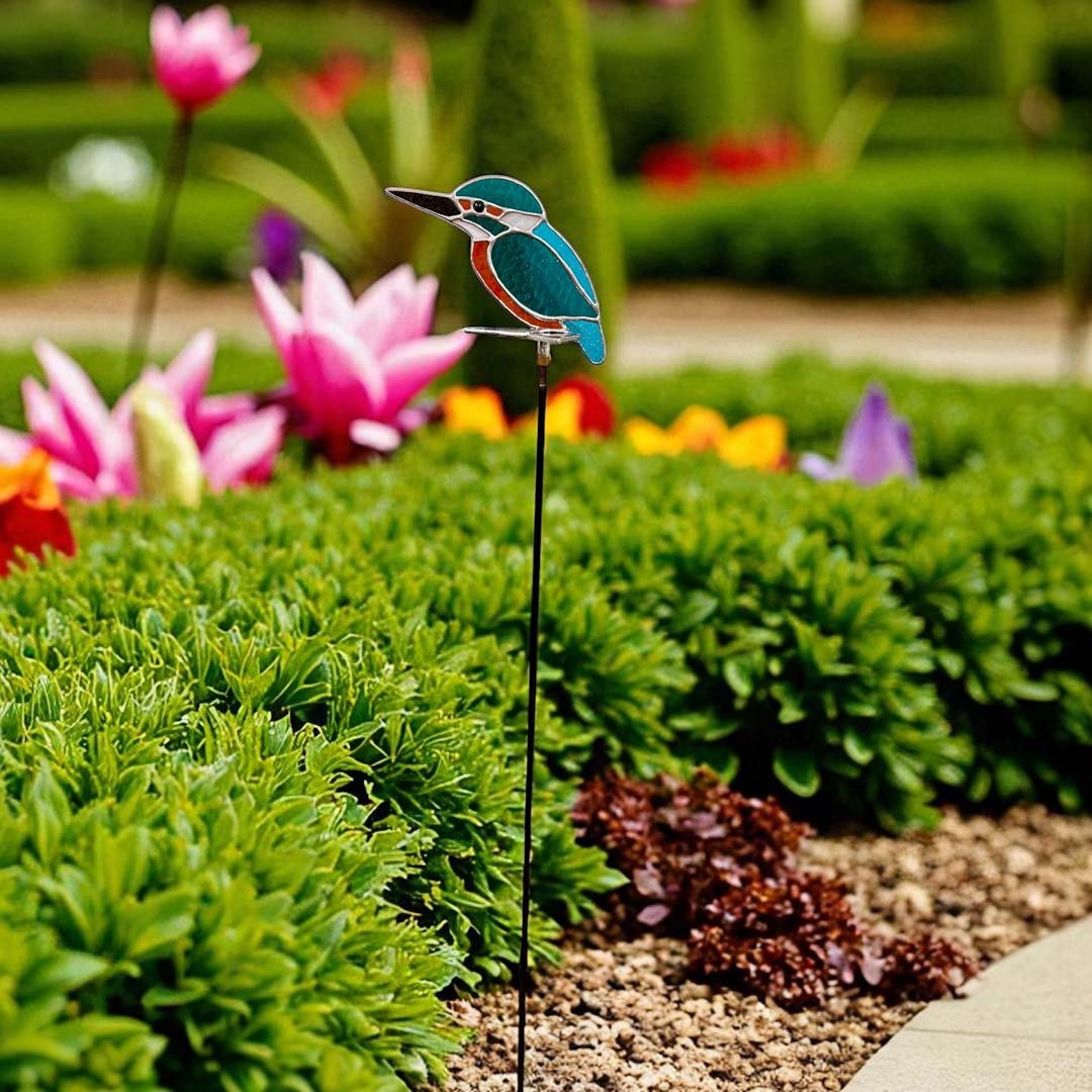 A stained glass kingfisher stake in a summer garden.
