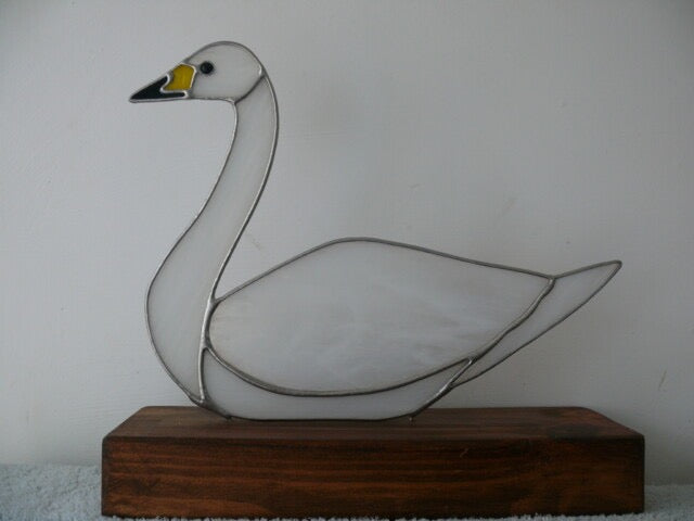 Stained glass swan on a wooden base against a plain background_Just Makers