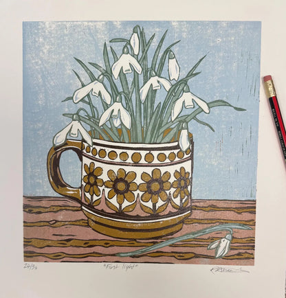 A square art print depicting white snowdrops blooming from a patterned ceramic mug on a wooden surface against a light blue background. A pencil is partially visible on the right edge of the print.