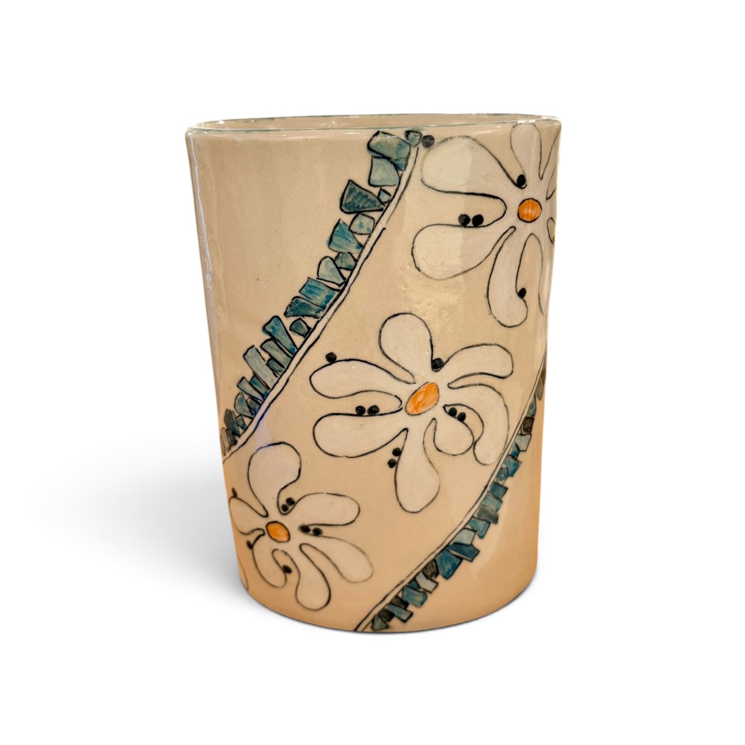 A handmade ceramic cup with a beige base, decorated with hand-painted white flowers, teal diagonal stripes, and small orange centers, shown on a white background.