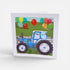 Card with a blue tractor and colorful balloons on a white background