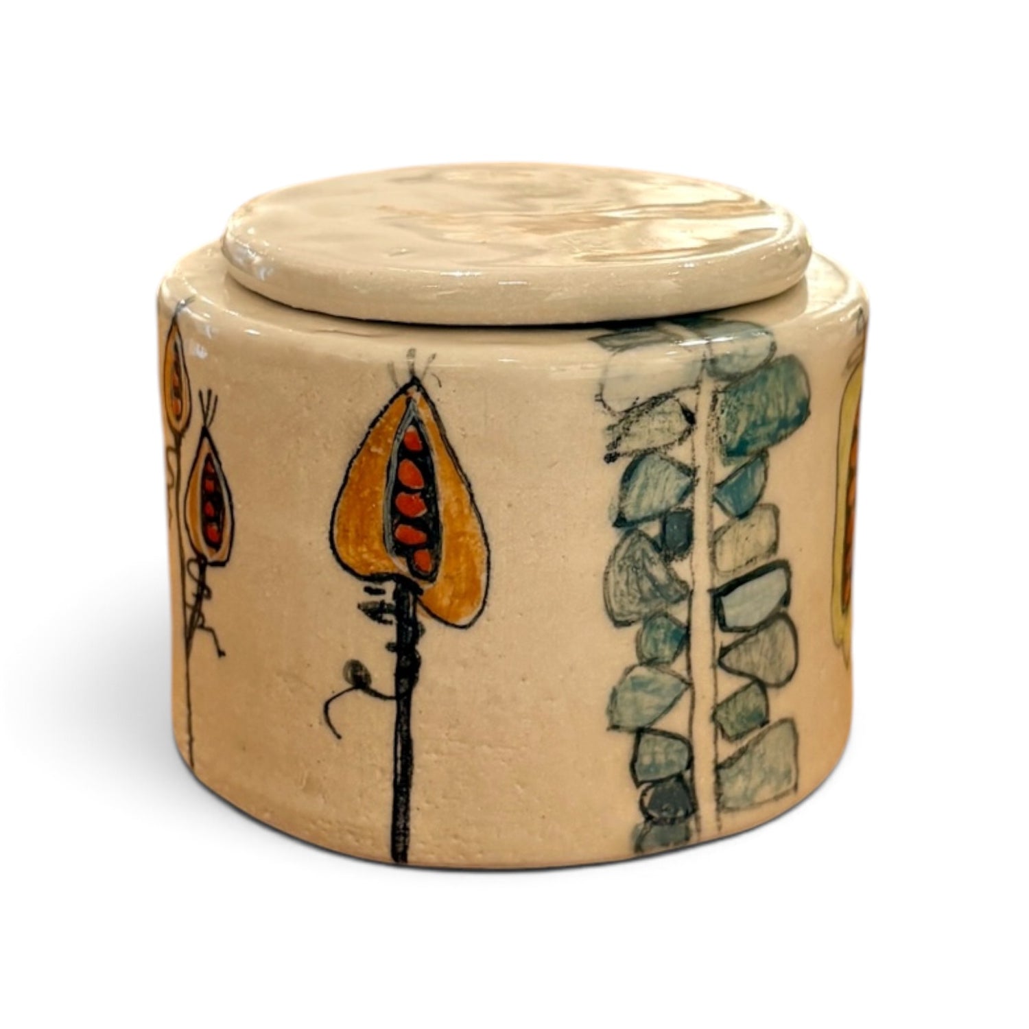A round ceramic lidded container with a beige base and hand-painted botanical motifs in orange, green, and black, shown on a plain white background.