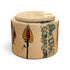 A round ceramic lidded container with a beige base and hand-painted botanical motifs in orange, green, and black, shown on a plain white background.
