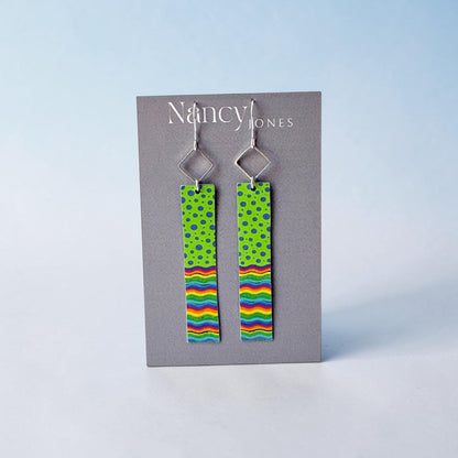 Pair of earrings with colorful patterns on a gray card with &