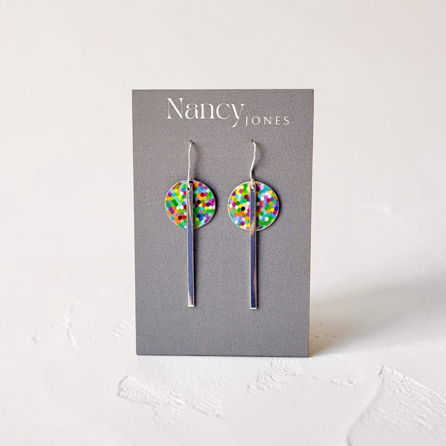 Colorful dot earrings on a Nancy Jones card against a white background