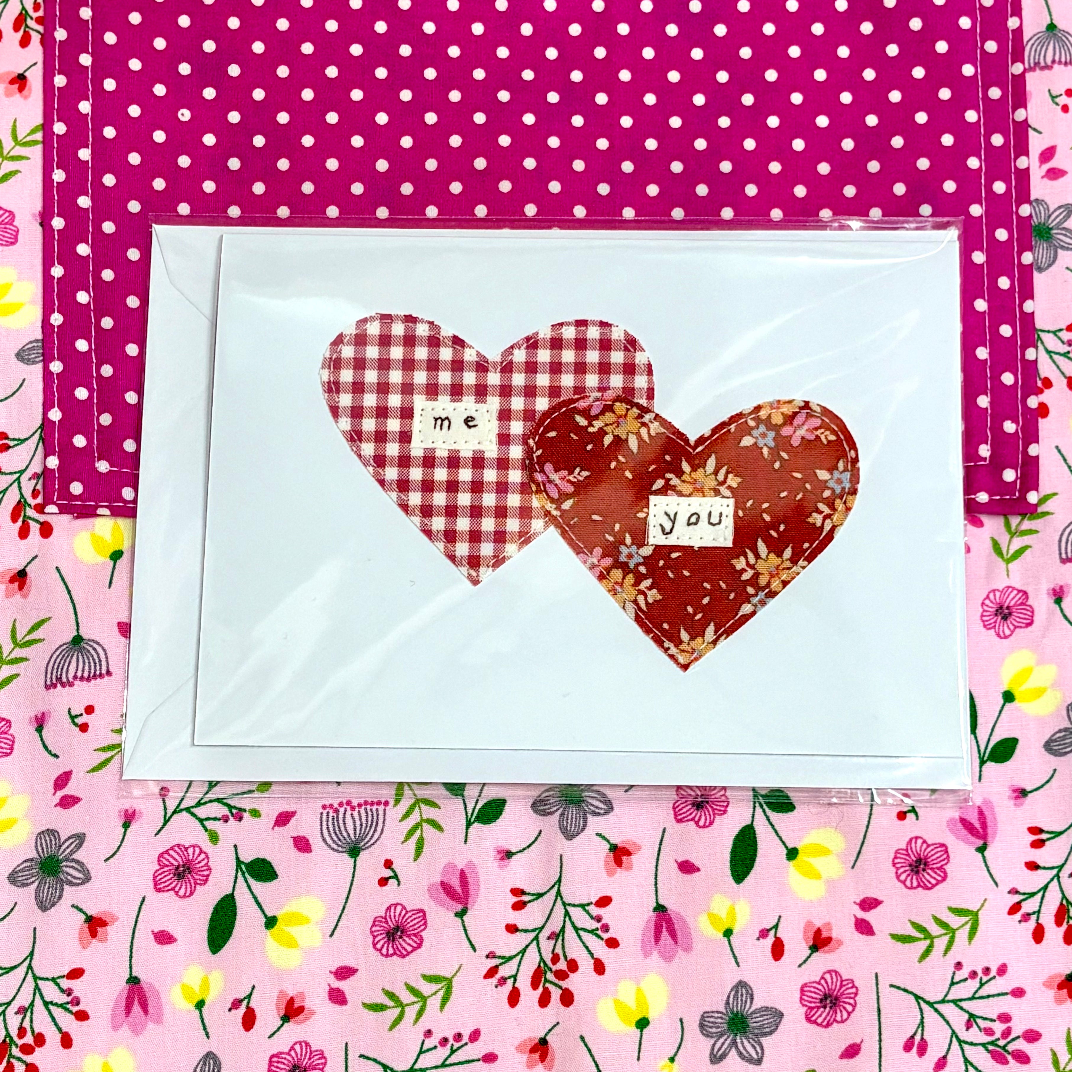 Two heart-shaped cards with text on a polka dot and floral patterned background