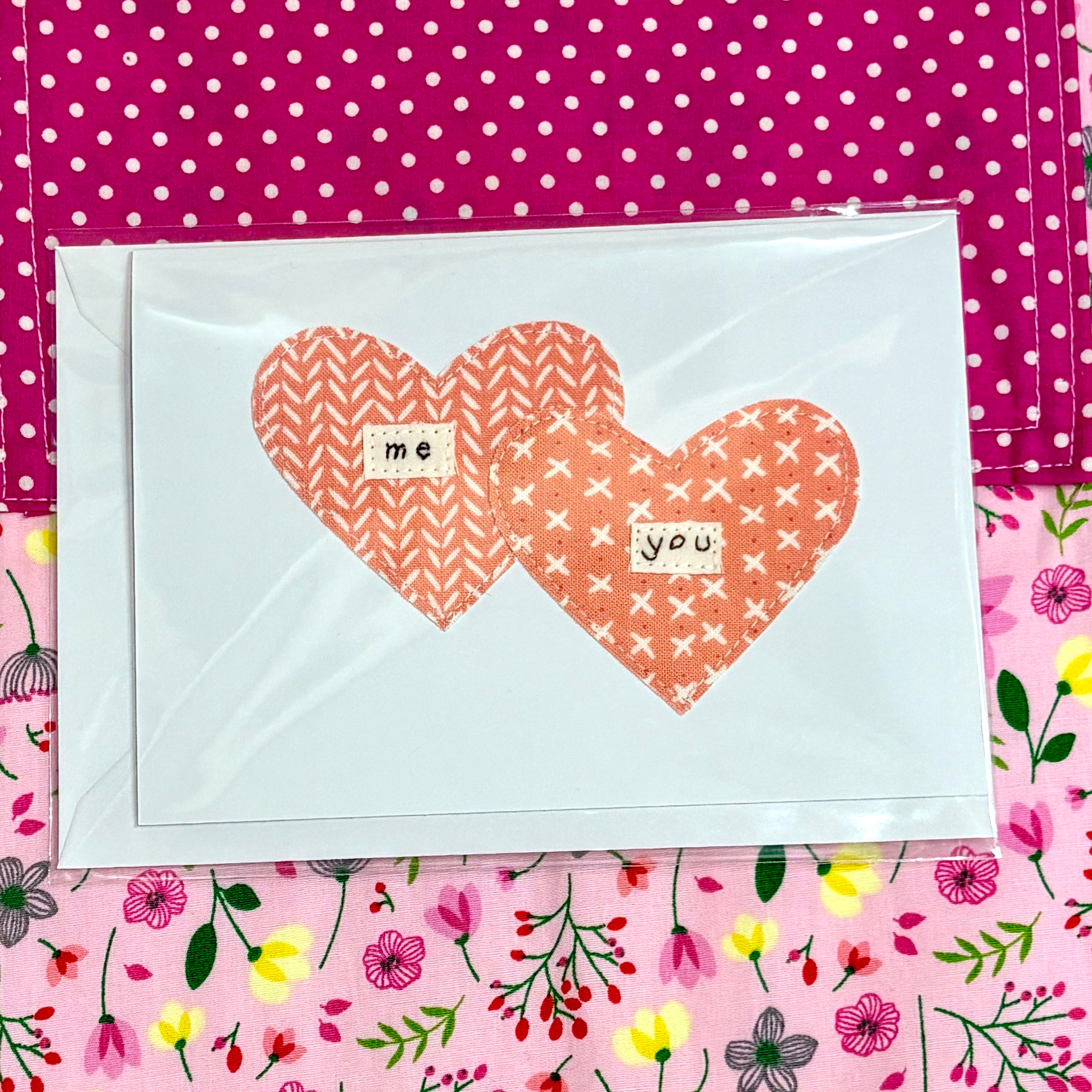 Card with two heart shapes and text on a polka dot and floral patterned background