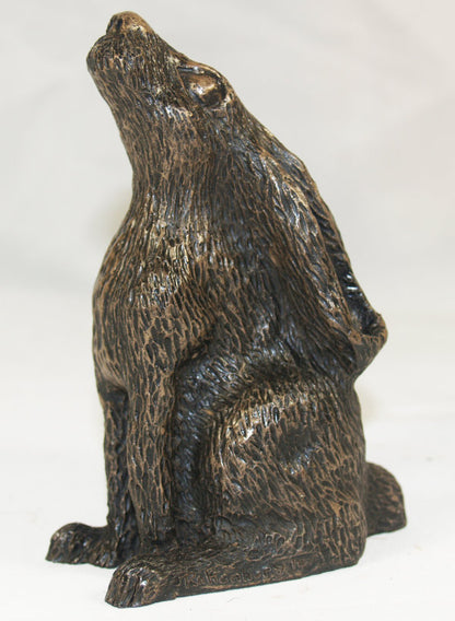 A dark bronze-finished sculpture of a seated hare, shown against a plain white background.