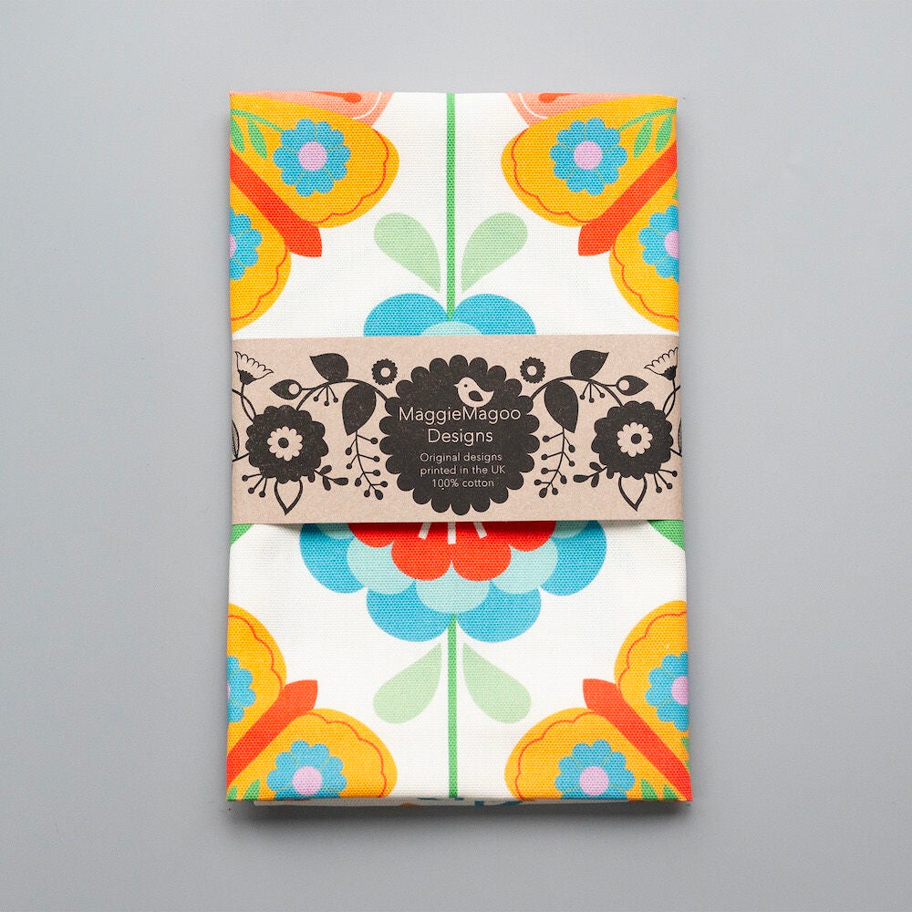 Packaged tea towel with colorful floral design and &