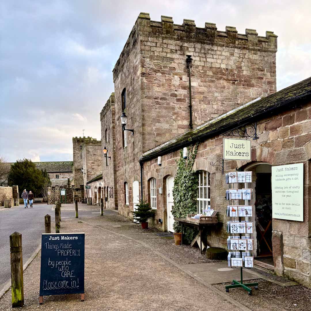Historic stone building with 'Just Makers' sign and outdoor display area.