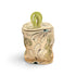A handmade ceramic lidded container with a whimsical, distorted shape, featuring a cream-colored body with abstract green, black, and blue painted patterns, topped with a glossy light green loop handle, set against a plain white background.