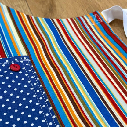 Colorful striped fabric with a blue polka dot pocket on a wooden surface_Just Makers