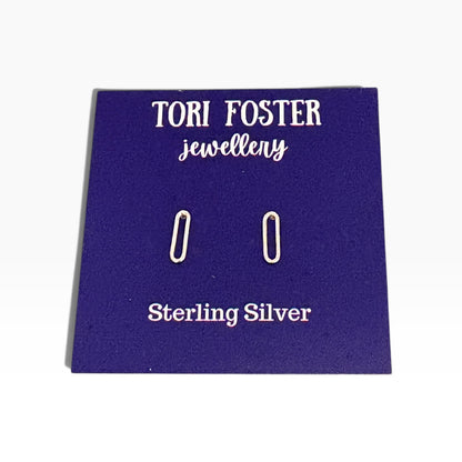 Sterling silver paperclip stud earrings on a purple Tori Foster Jewellery display card, photographed against a white background.