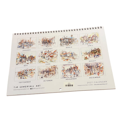 A spiral-bound 2027 wall calendar from Tim Comersall Art, displayed at an angle on a clean white background. The cover features twelve square watercolor illustrations of street scenes, each labeled with its respective month.