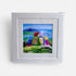 Framed artwork of colorful characters with backpacks against a mountainous landscape.