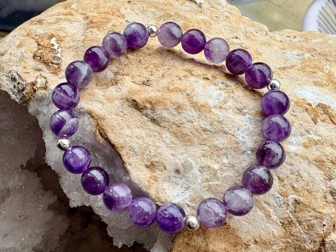 Purple beaded bracelet on a textured stone surface