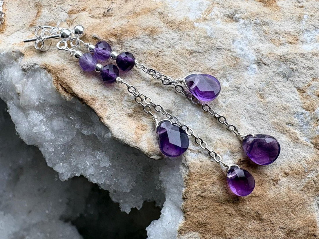 Purple beaded earrings on a stone surface