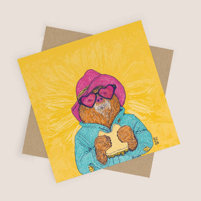 Greeting card with a bear illustration wearing a pink hat and sunglasses on a yellow background
