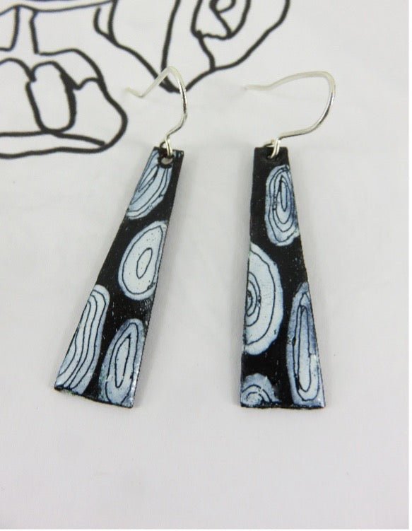 Black and white patterned earrings on a light gray background