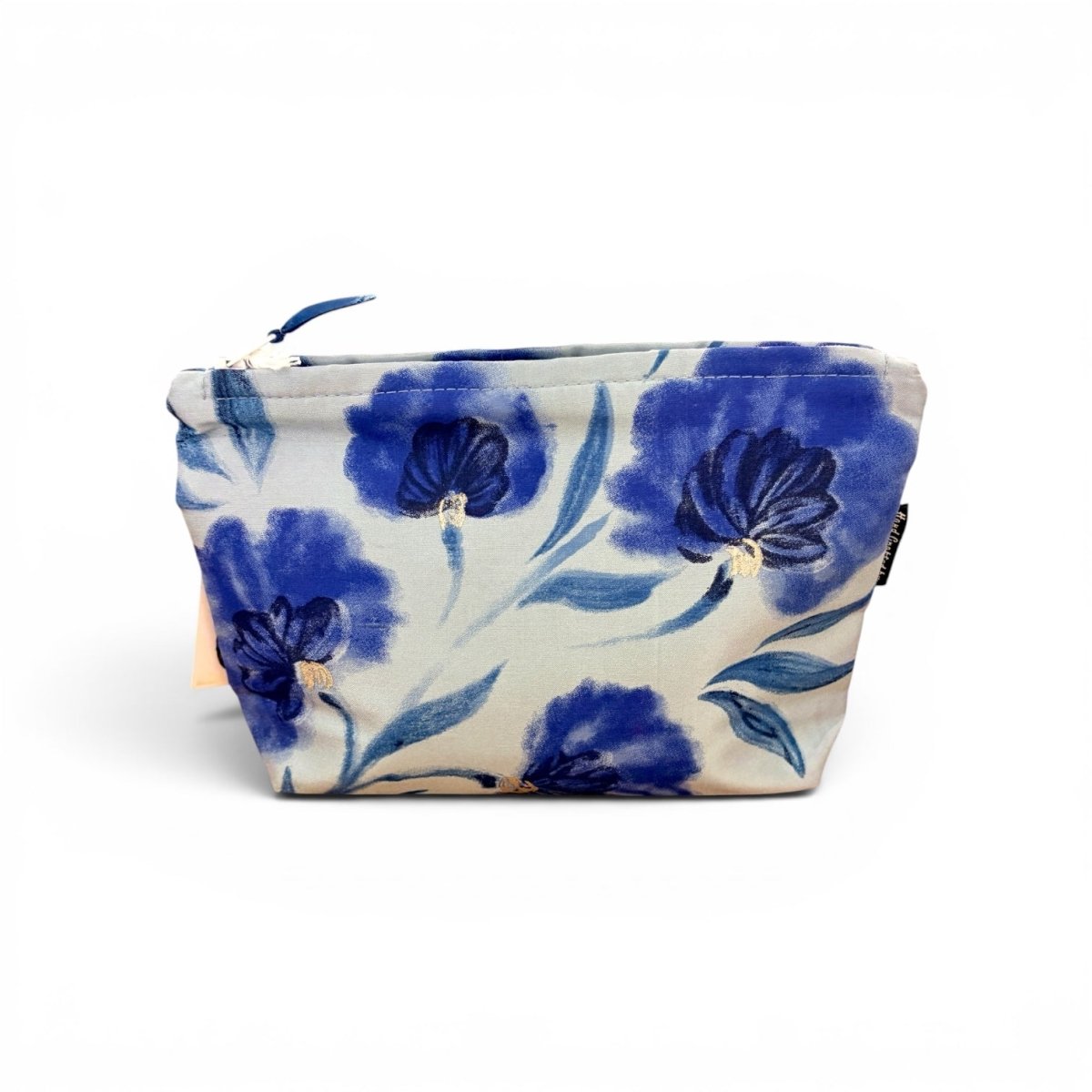 A fabric zippered pouch featuring a blue floral watercolor pattern on a cream background, with a blue zipper pull and a small black brand tag on the side.