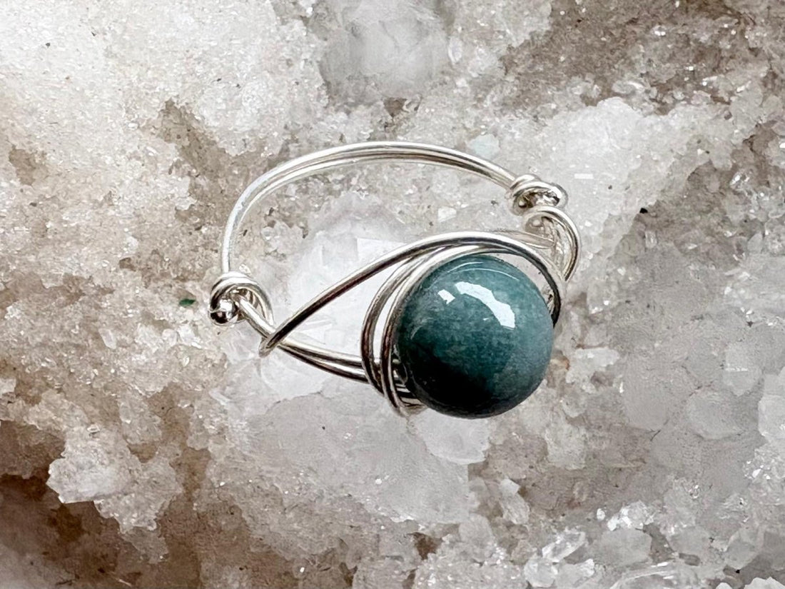 Silver ring with a blue stone on a crystal background