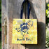Yellow tote bag with bee design hanging on a wooden door