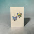 Butterfly earrings on a Nancy Jones card against a gray background