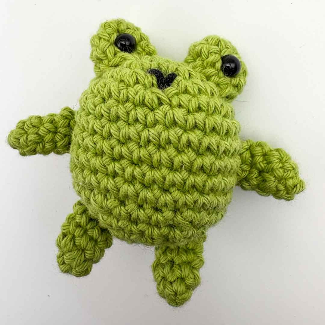 Green crocheted frog toy on a white background_Hooked on Yarn_Just Makers