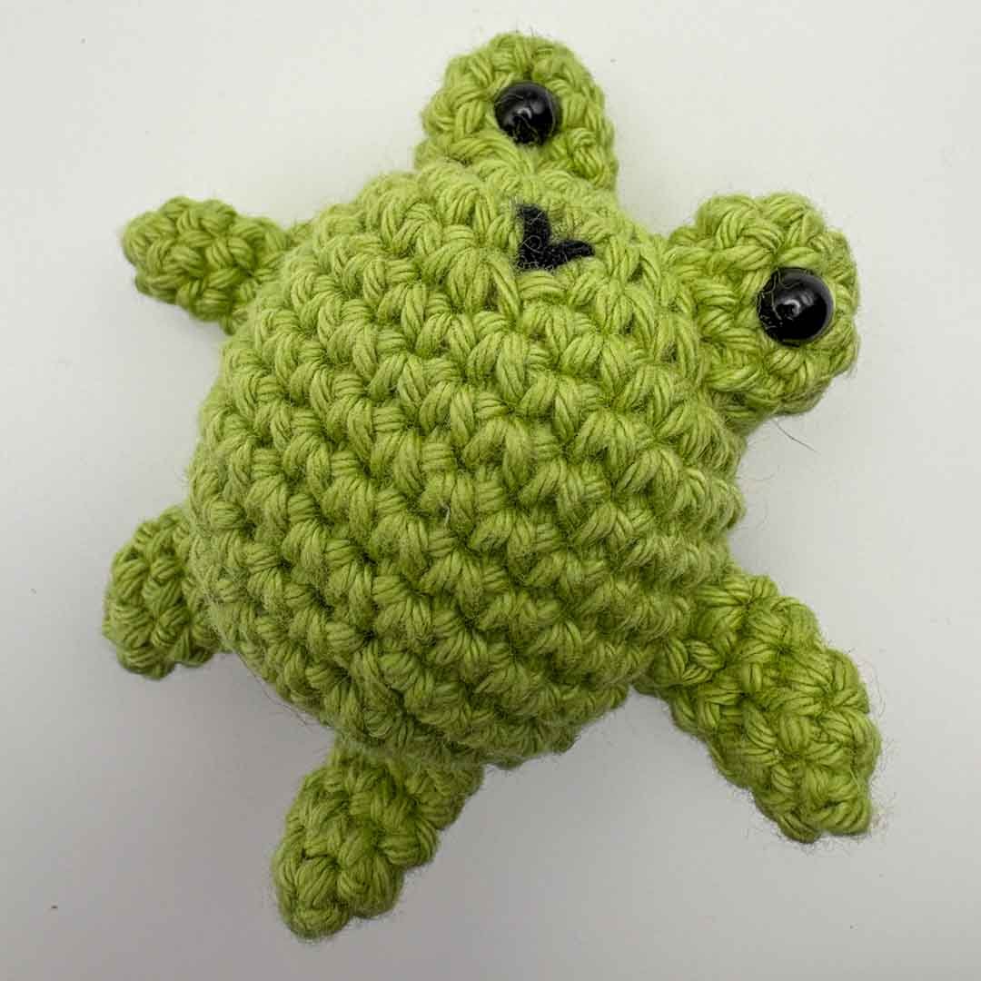 Green crochet turtle toy on a white background_Just Makers