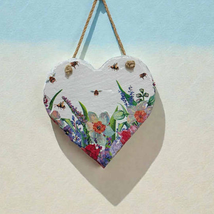 Heart-shaped wooden plaque with floral design hanging on a light blue and beige background